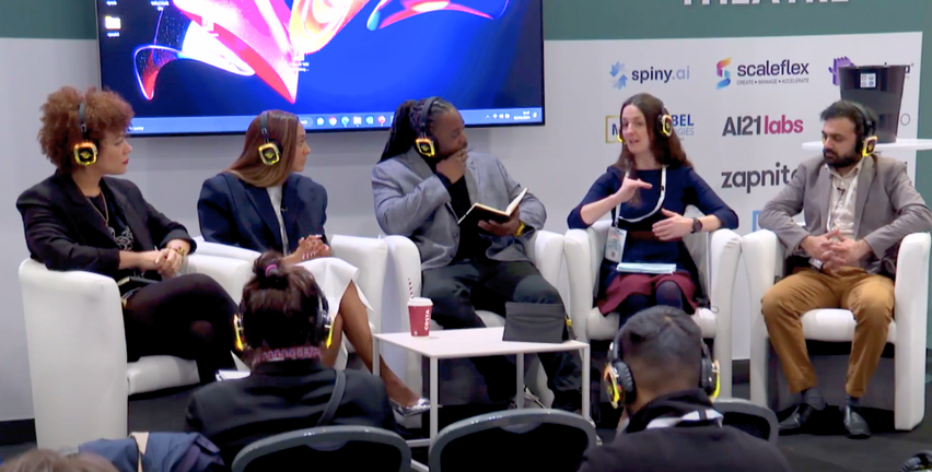 a diverse group of five people sitting on chairs in front of a screen wearing headphones